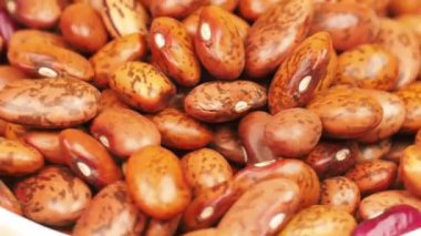Genç kızın elleri ahşap bir çevre dostu tabağı tutuyor çiğ protein çekirdekleri ve parlak sarı arka planda bir kaşıkla karıştırıyor.