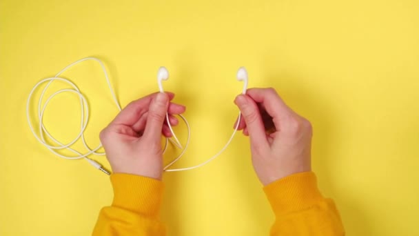 Młoda Kobieta Trzyma Białe Słuchawki Tańczy Muzyki Żółtym Tle — Wideo stockowe