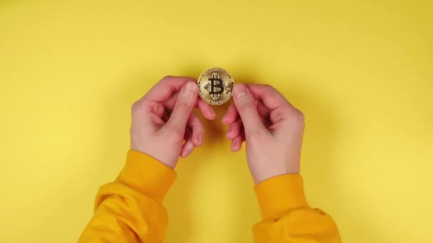 Mani Una Giovane Ragazza Maglione Tengono Bitcoin Oro Uno Sfondo — Video Stock