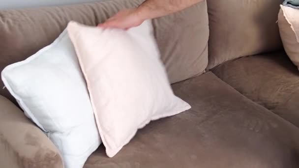 男性手置く多くのカラフルな枕上の柔らかい居心地の良いソファでザリビングルーム — ストック動画