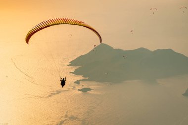 Gün batımında Oludeniz üzerinde uçan paraglider. Tatil ve Yaz arkaplanı.