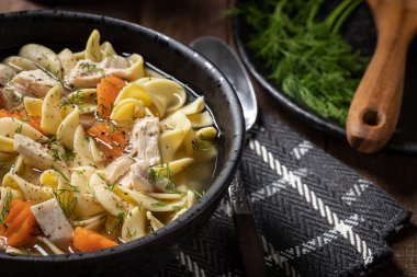 Bir kase tavuklu erişte çorbası, havuç ve dereotlu.