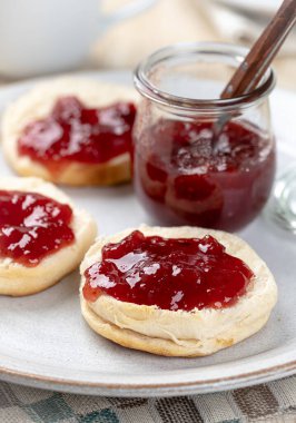 Bisküviler bir tabağa çilek reçeli serpiştirilmiş.