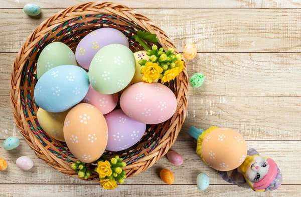 Colorful Easter Eggs Yellow Flowers Basket Wooden Table Overhead View — Stock Photo, Image