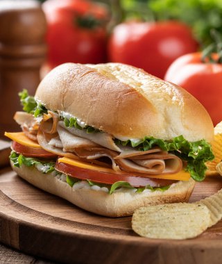 Hindili, marullu, peynirli, domatesli, domatesli ve marullu sandviç.