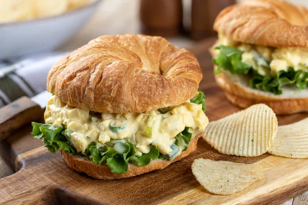 Egg Salad Sandwich Lettuce Croissant Potato Chips Wooden Cutting Board — стоковое фото