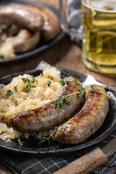 Grilled Bratwurst Sauerkraut Garnished Thyme Black Plate — Stock Fotó