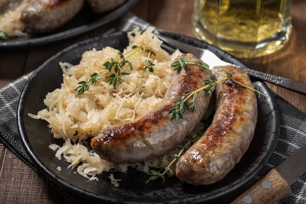 Grilled Bratwurst Sauerkraut Garnished Thyme Black Plate — Fotografia de Stock