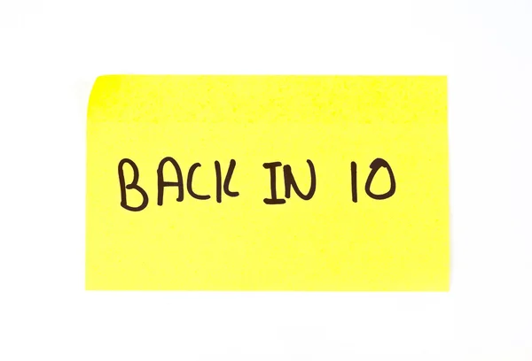 'Back In 10' escrito em uma nota pegajosa — Fotografia de Stock