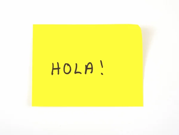 'Hola' written on a yellow sticky note (hello in Spanish) — Stock Photo, Image