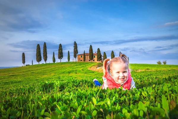 Little girl smiling and playing on a meadow in front of a Tuscan — Stock Photo, Image