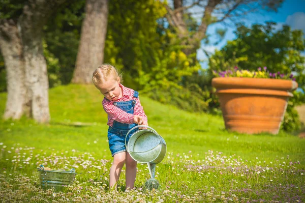 Dziewczynka pomaga w pracach lato w ogrodzie — Zdjęcie stockowe