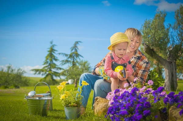 Liten flicka med sin mamma i trädgården — Stockfoto