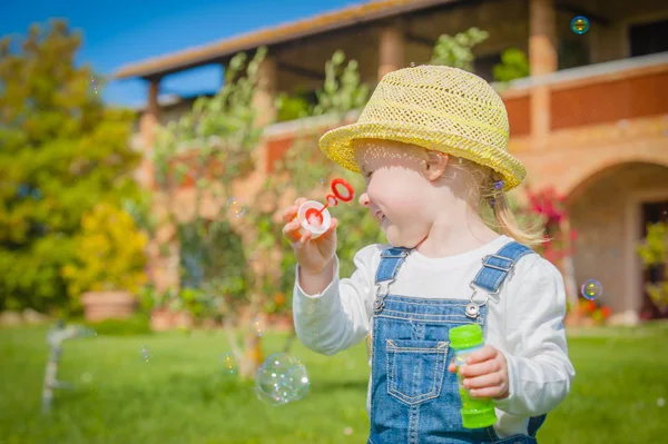 Girl with bubbles on green summer the grass — Stock Photo, Image