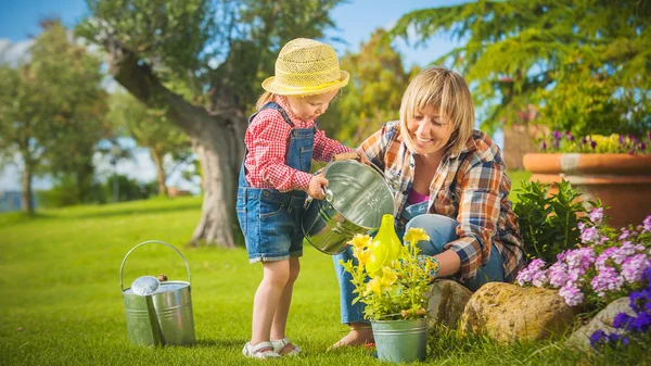 Little girl helping her mother in the garden — Stock Photo, Image