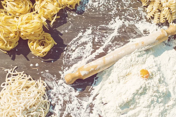 Pasta egg in flour and a rolling pin. — Stock Photo, Image