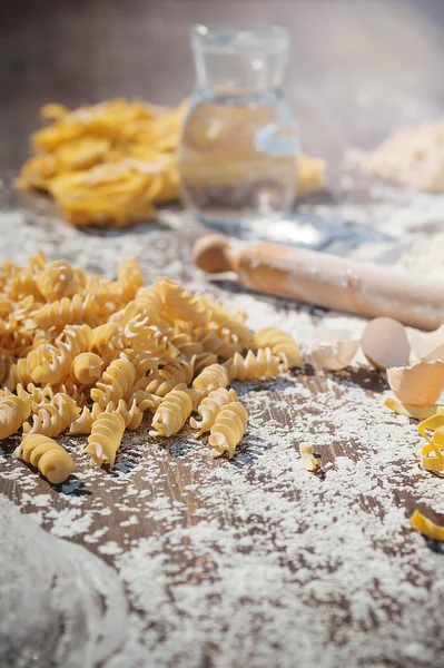 Pasta egg in flour and a rolling pin. — Stock Photo, Image