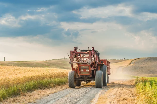 Tractor with a trailer on the fields in Tuscany, Italy — Stock Photo, Image