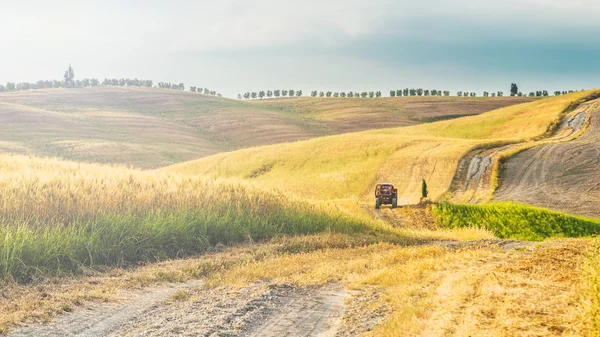 Tractor with a trailer on the fields in Tuscany, Italy — Stock Photo, Image