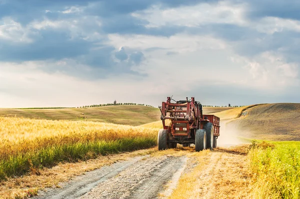 Traktor mit Anhänger auf Feldern in der Toskana, Italien — Stockfoto