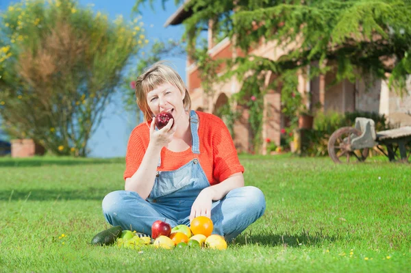 Frau mit Früchten im grünen Gras — Stockfoto