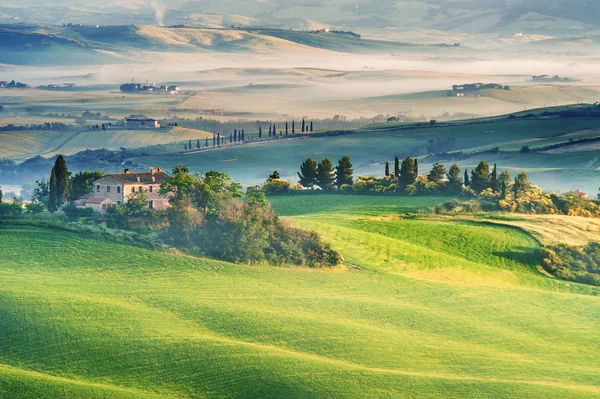 Der geheimnisvolle Nebel, der das toskanische Haus und die Felder umgibt, Italien — Stockfoto