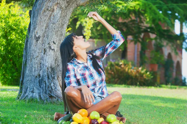 Atrakcyjna kobieta jedzenie winogrona białe na zewnątrz — Zdjęcie stockowe