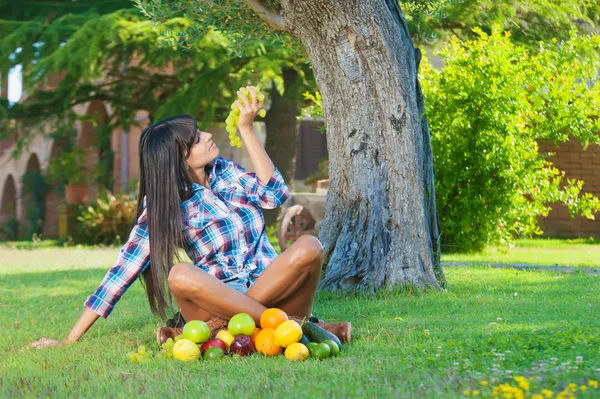 Atrakcyjna kobieta jedzenie winogrona białe na zewnątrz — Zdjęcie stockowe