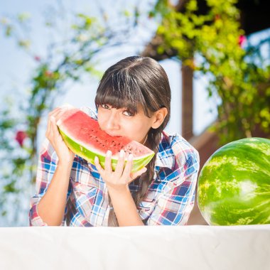güneşli bir günde sağlıklı genç kadın yiyen karpuz