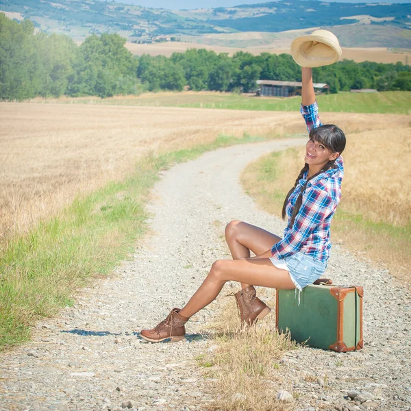 Beautiful brazilian woman with a suitcase on a road trip. — Stock Photo, Image