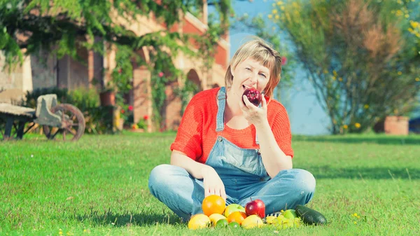 Woman with fruits on green grass — Stock Photo, Image