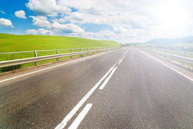 arka plan mavi gökyüzü ile yeşil alanlar arasında uzun bir yol