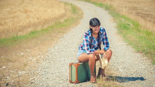 Beautiful brazilian woman with a suitcase on a road trip. Royalty Free Stock Photos