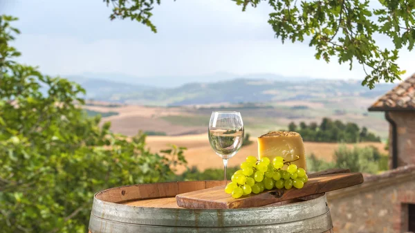 Käse und Trauben auf einem Fass in der toskanischen Landschaft Italien — Stockfoto