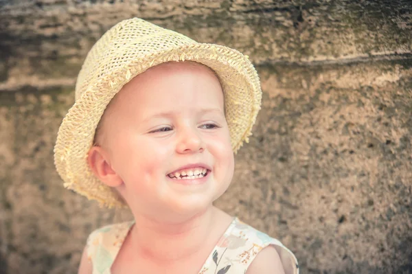 Laughing gorgeous and beautiful little girl in a straw hat — Stock Photo, Image