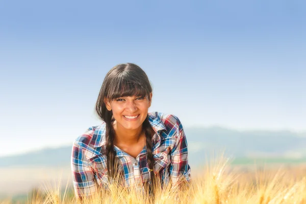 Smiling beautiful young brazilian girl on a yellow crop field — Stock Photo, Image