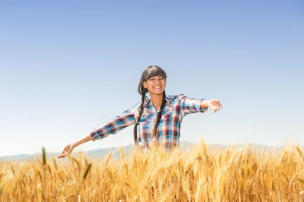 Smiling beautiful young brazilian girl on a yellow crop field — Stock Photo, Image