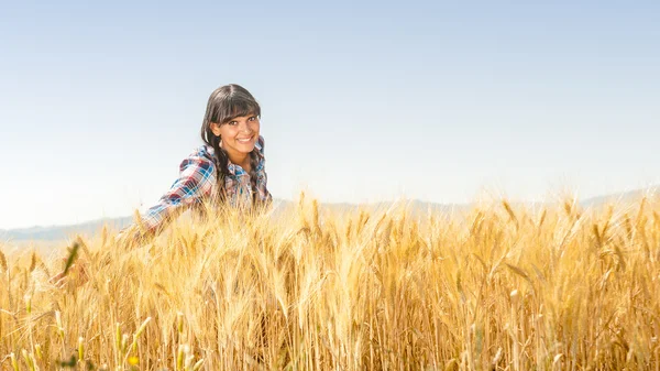 Smiling beautiful young brazilian girl on a yellow crop field — Stock Photo, Image