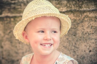 çok güzel ve güzel küçük kız bir hasır şapka gülüyor