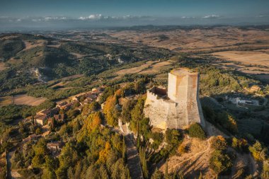 İnsansız hava aracı İtalya 'da gün batımında Rocca d' Orcia üzerinde uçuyor.