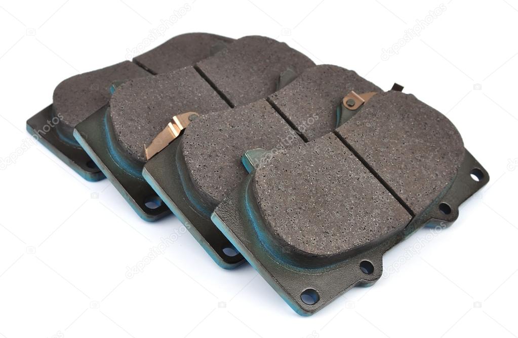 Four clean isolated disc brake pads.