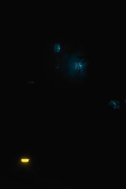 Sisteki bir gece evinin penceresinden gelen ışık.