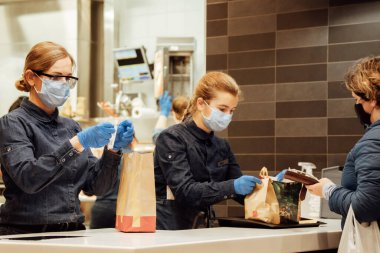 McDonalds personeli müşterilerine siparişlerini veriyor..