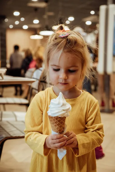 Malá holka jí vanilkovou zmrzlinu — Stock fotografie