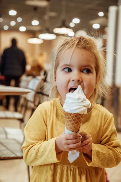 Malá holka jí vanilkovou zmrzlinu — Stock fotografie