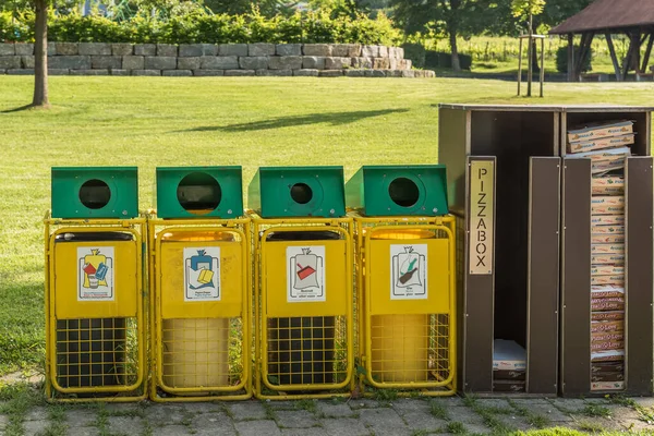 Hagnau am Bodensee, Baden-Wuerttemberg, Almanya - 15 Haziran 2022. Kamu parkında çöp kutuları çöp ayrıştırma, plastik, kağıt, diğer atıklar, cam ve kullanılmış pizza kutuları için. Çöp geri dönüşüm kavramı. 