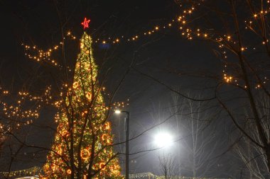 Yıldızlı noel ağacı ve renkli parlak toplar ve gece çelenkleri