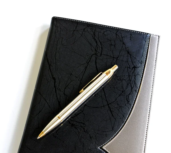 Pluma acostada en un cuaderno — Foto de Stock