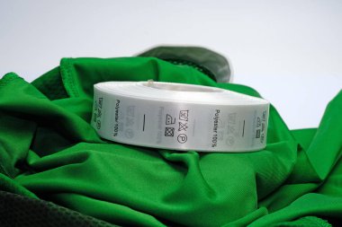 Giysiler için kefen etiketleri, giysi kullanımı için sembollü saten kurdeleler. Çamaşır talimatlarıyla% 100 Polyester kumaş etiketi. Elbisenin içine dikilmiş etiketler..
