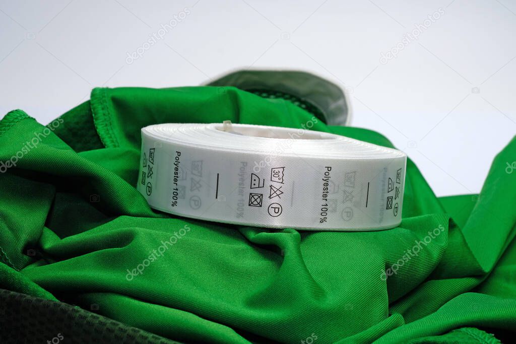 Skein tags for clothing, satin ribbon with symbols for the use of clothing. Green 100 % Polyester fabric Clothing label with laundry instructions. Labels that are sewn to the inside of the garment.